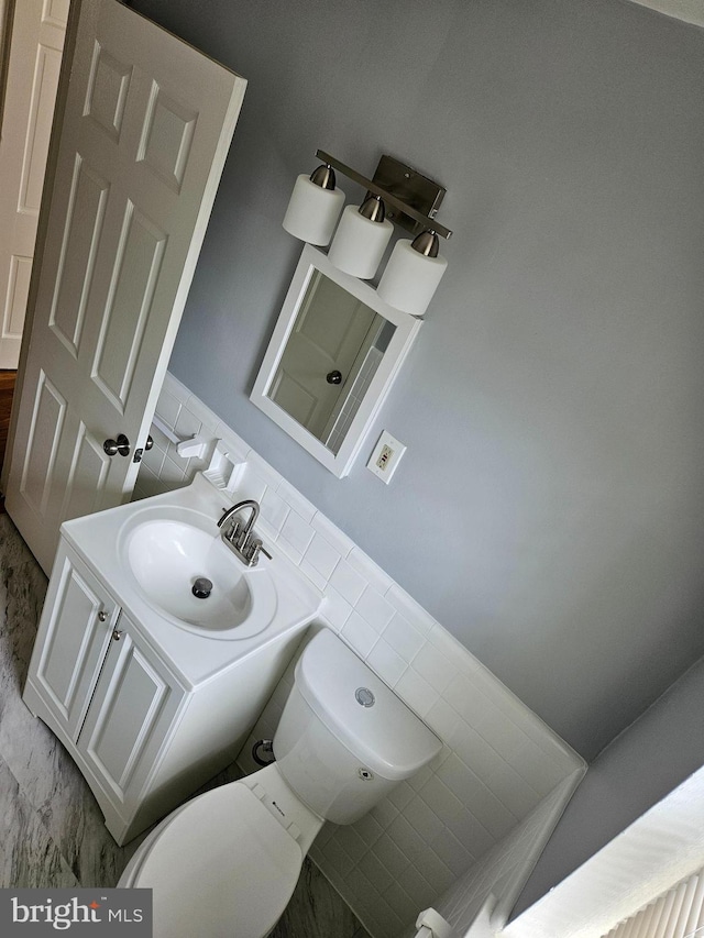 half bathroom with vanity and toilet