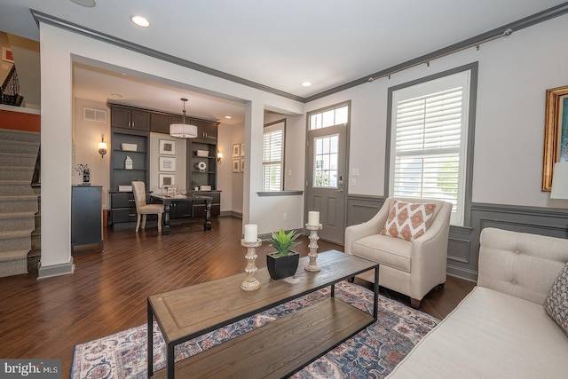 living room featuring visible vents, crown molding, dark wood finished floors, stairway, and a wainscoted wall