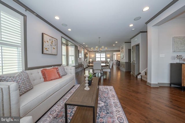 living room with recessed lighting, ornamental molding, dark wood finished floors, and a notable chandelier