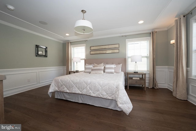 bedroom with wainscoting, ornamental molding, a decorative wall, and dark wood-type flooring