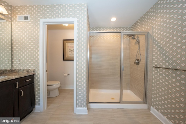 bathroom featuring visible vents, toilet, baseboards, wallpapered walls, and a shower stall