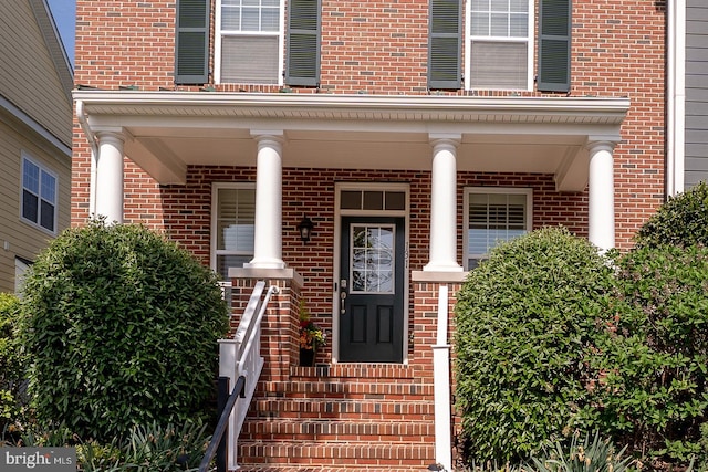 property entrance featuring brick siding and a porch
