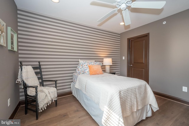bedroom featuring wallpapered walls, baseboards, and an accent wall