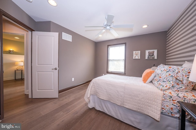 bedroom featuring ceiling fan, visible vents, wood finished floors, baseboards, and recessed lighting