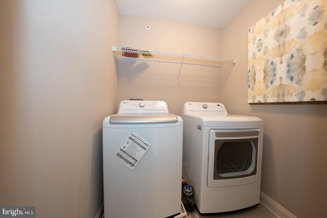 laundry room featuring separate washer and dryer, baseboards, and laundry area