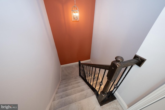 staircase with baseboards and carpet flooring