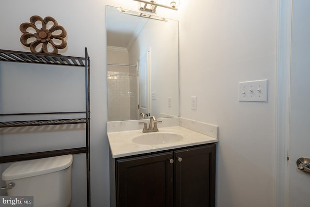 bathroom with vanity, ornamental molding, and toilet