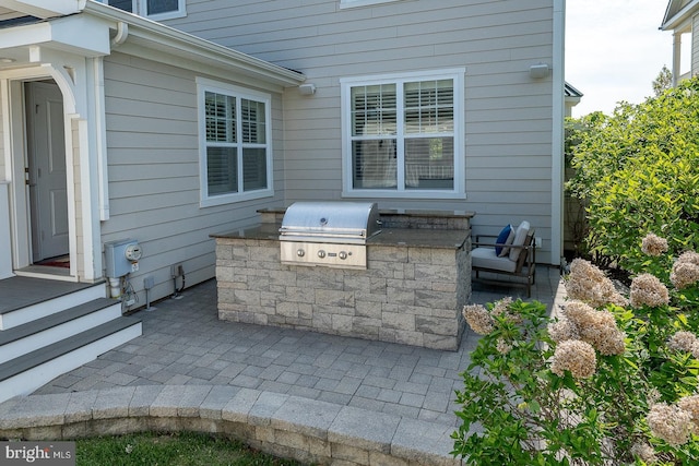 view of patio / terrace featuring exterior kitchen and a grill