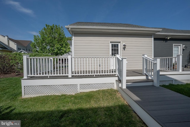 rear view of property featuring a lawn and a deck