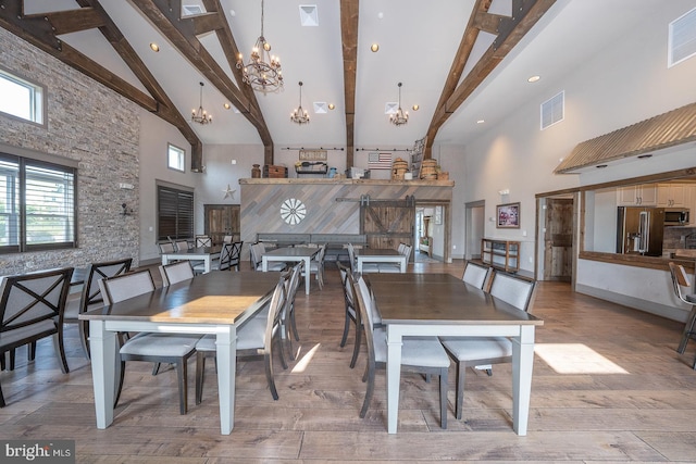 dining space featuring high vaulted ceiling, beam ceiling, and a notable chandelier