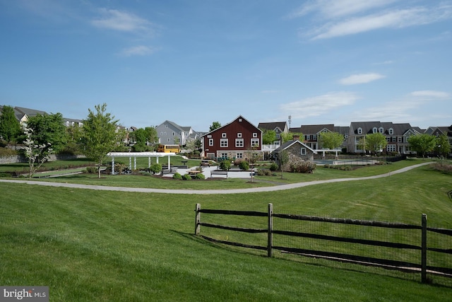 view of home's community featuring a residential view, fence, and a yard
