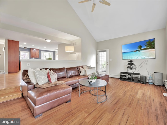 living area with high vaulted ceiling, a ceiling fan, light wood finished floors, and visible vents