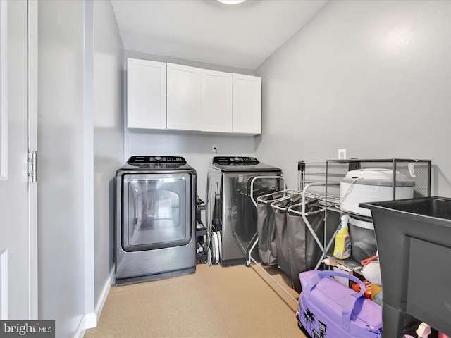 laundry area featuring separate washer and dryer, baseboards, and cabinet space