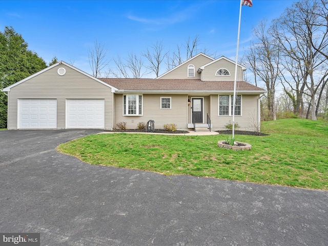 view of front of property featuring a shingled roof, an attached garage, a front lawn, and aphalt driveway