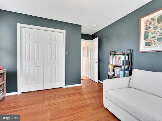 sitting room with baseboards and light wood finished floors
