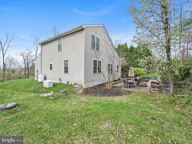rear view of property featuring a lawn and a patio area
