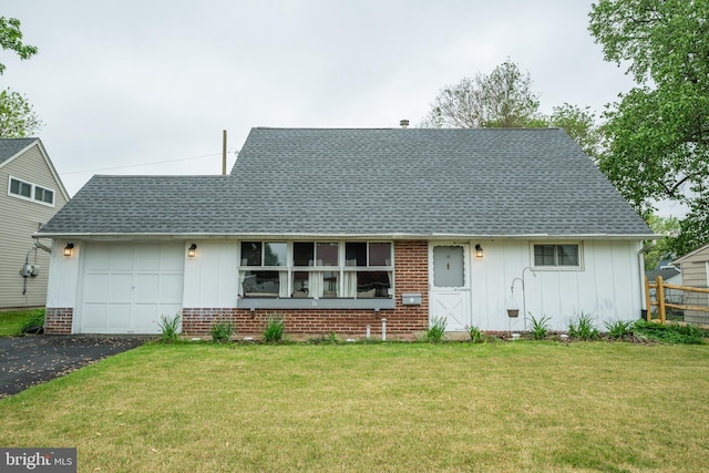 view of front facade with board and batten siding, brick siding, an attached garage, a shingled roof, and a front lawn
