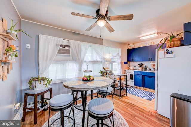 dining room featuring a ceiling fan, light wood-style flooring, and a wall mounted AC