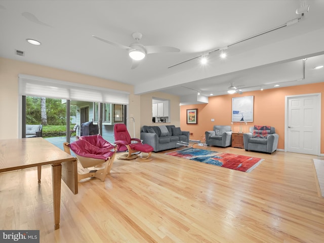 living room featuring a ceiling fan, wood finished floors, track lighting, and recessed lighting
