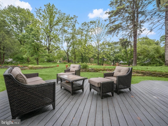 deck featuring an outdoor hangout area, a yard, and view of wooded area