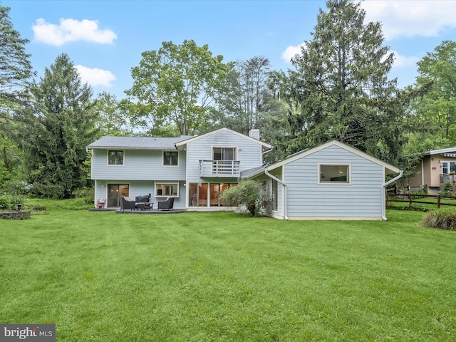 rear view of property with a balcony, a patio, and view of scattered trees