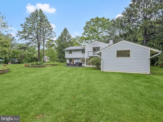 back of property featuring a yard, view of scattered trees, and a chimney