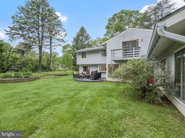 back of house with an outdoor hangout area, a balcony, a yard, and a patio area