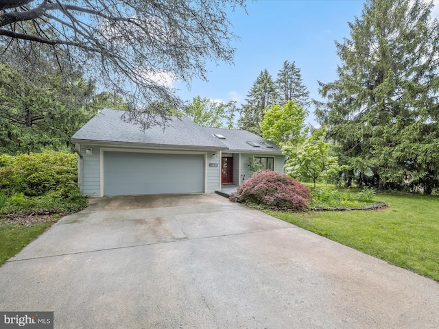 view of front facade featuring driveway, an attached garage, a front lawn, and a shingled roof