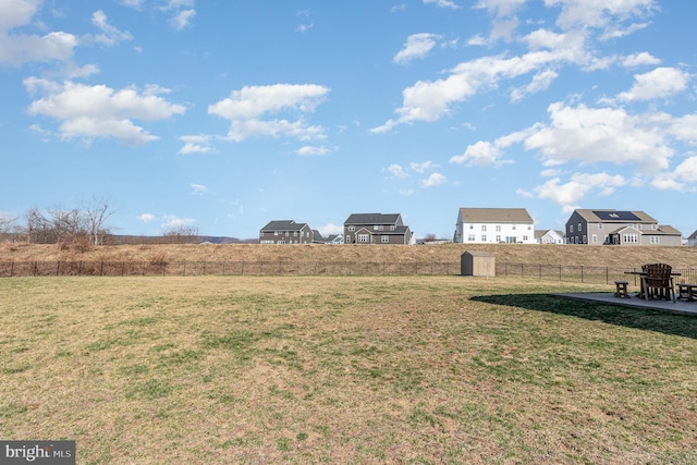 view of yard featuring an outdoor structure, a patio, a fenced backyard, and a storage unit