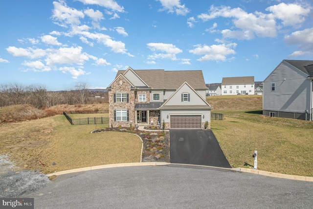 view of front of property with stone siding, a garage, fence, aphalt driveway, and a front lawn
