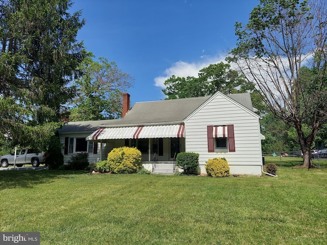 view of front of house featuring a chimney and a front yard