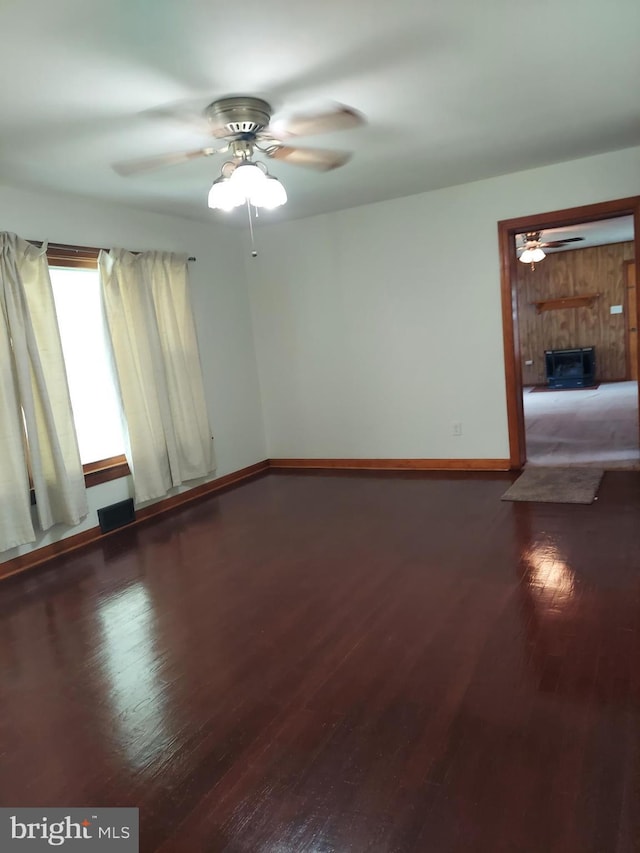 unfurnished room with a ceiling fan, baseboards, and wood finished floors