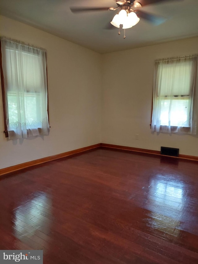 empty room featuring baseboards, a ceiling fan, and wood finished floors