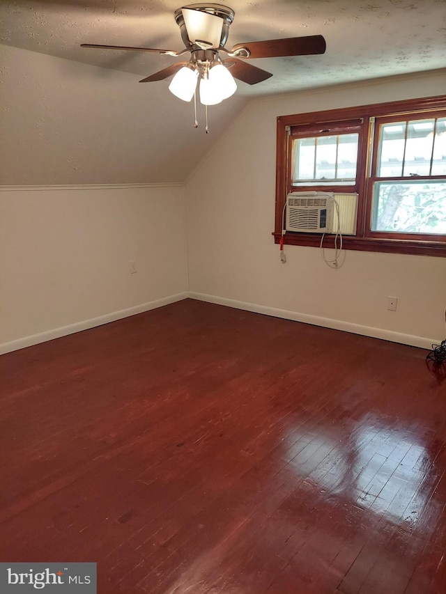 additional living space featuring cooling unit, dark wood finished floors, a ceiling fan, baseboards, and lofted ceiling