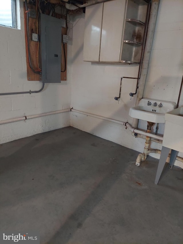 basement with a sink and electric panel