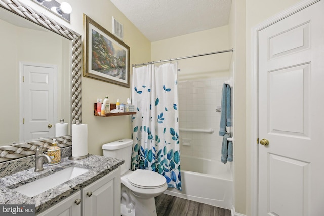 bathroom featuring wood finished floors, vanity, toilet, shower / bathtub combination with curtain, and a textured ceiling