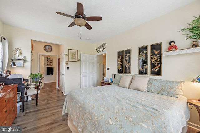 bedroom with wood finished floors, baseboards, and ceiling fan