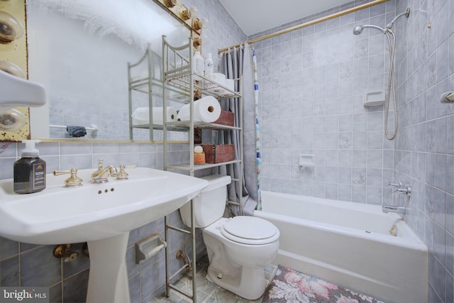 full bathroom with shower / bath combo with shower curtain, tasteful backsplash, toilet, and tile walls