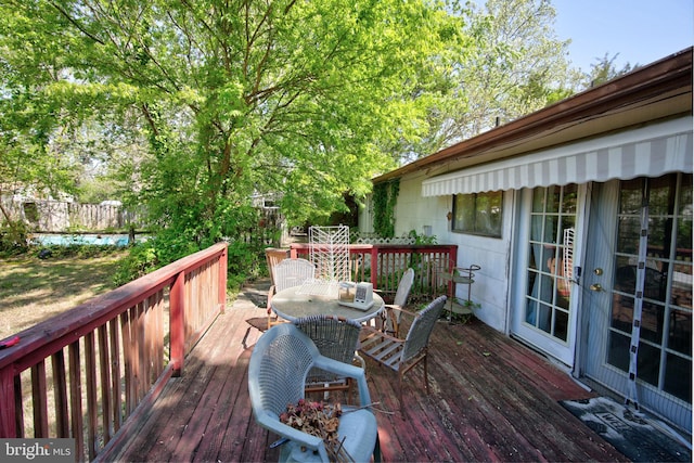 wooden deck featuring french doors, fence, and outdoor dining area