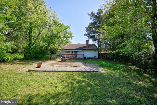 view of yard with a patio, a fenced backyard, and a wooden deck