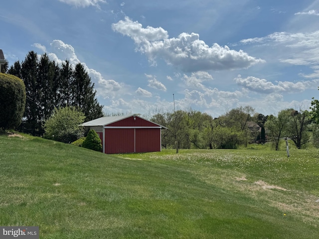 view of yard featuring an outdoor structure, a pole building, and a detached garage