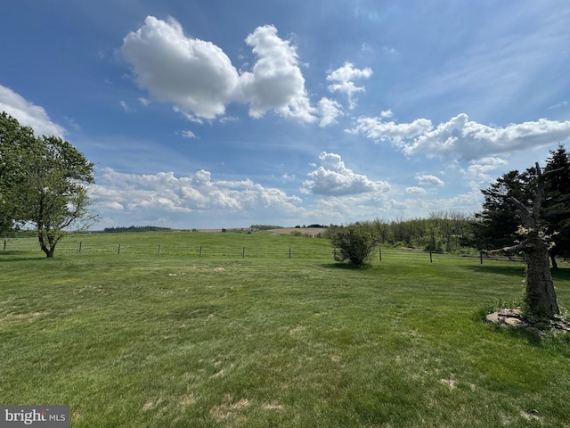 view of yard featuring a rural view and fence