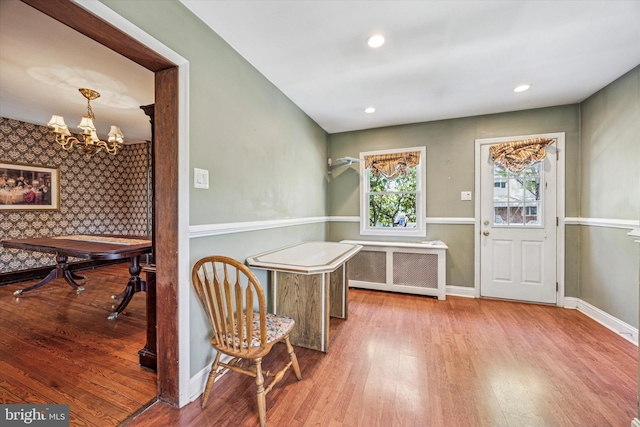 interior space featuring a notable chandelier, radiator heating unit, recessed lighting, baseboards, and wood finished floors