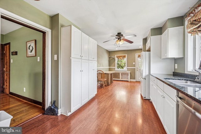 kitchen with ceiling fan, dishwasher, a sink, freestanding refrigerator, and light wood finished floors