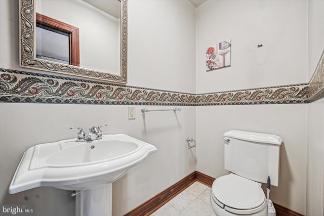 bathroom with a sink, tile patterned flooring, and toilet