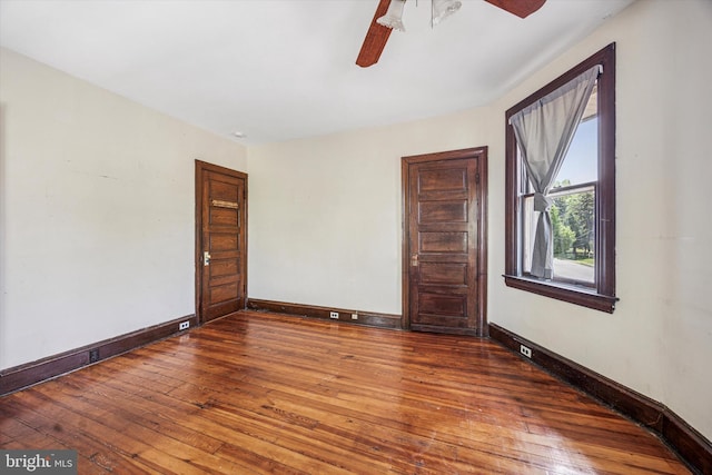 empty room with wood-type flooring, ceiling fan, and baseboards