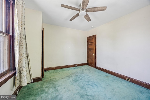 empty room featuring carpet floors, a ceiling fan, and baseboards