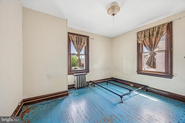 game room with baseboards, radiator heating unit, and hardwood / wood-style flooring
