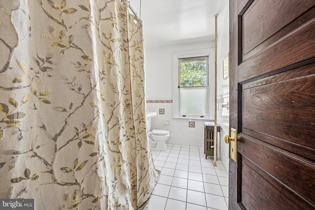 full bathroom featuring wainscoting, tile patterned flooring, toilet, radiator heating unit, and tile walls