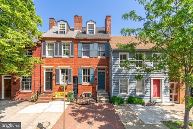 view of front of property with brick siding and a chimney
